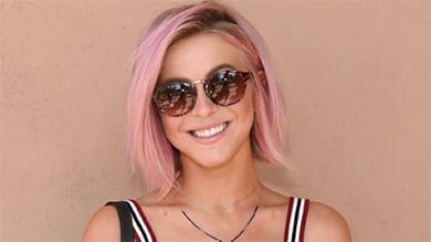 woman with pink hair wearing glasses