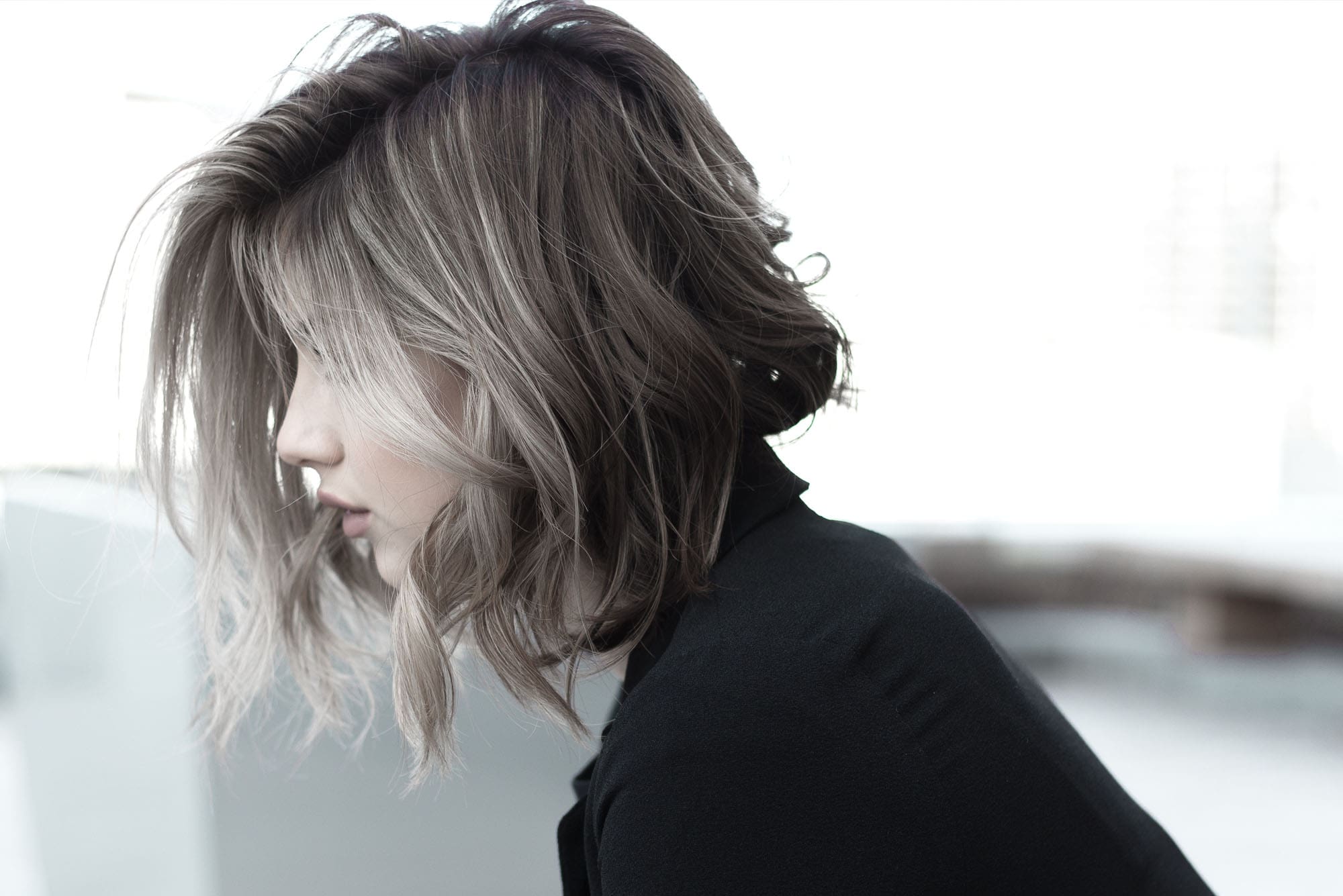 A woman with short hair is looking down.